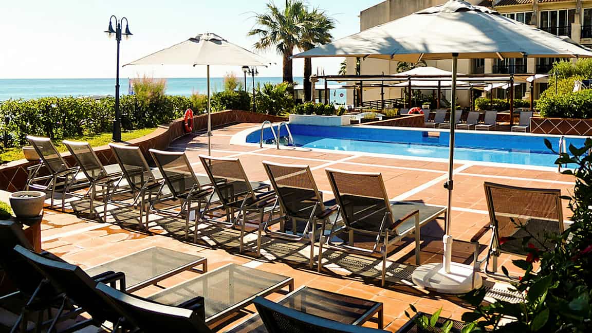 Ulkouima-allas, jossa on aurinkotuoleja ja aurinkovarjoja. (Tekoälyn luoma teksti)