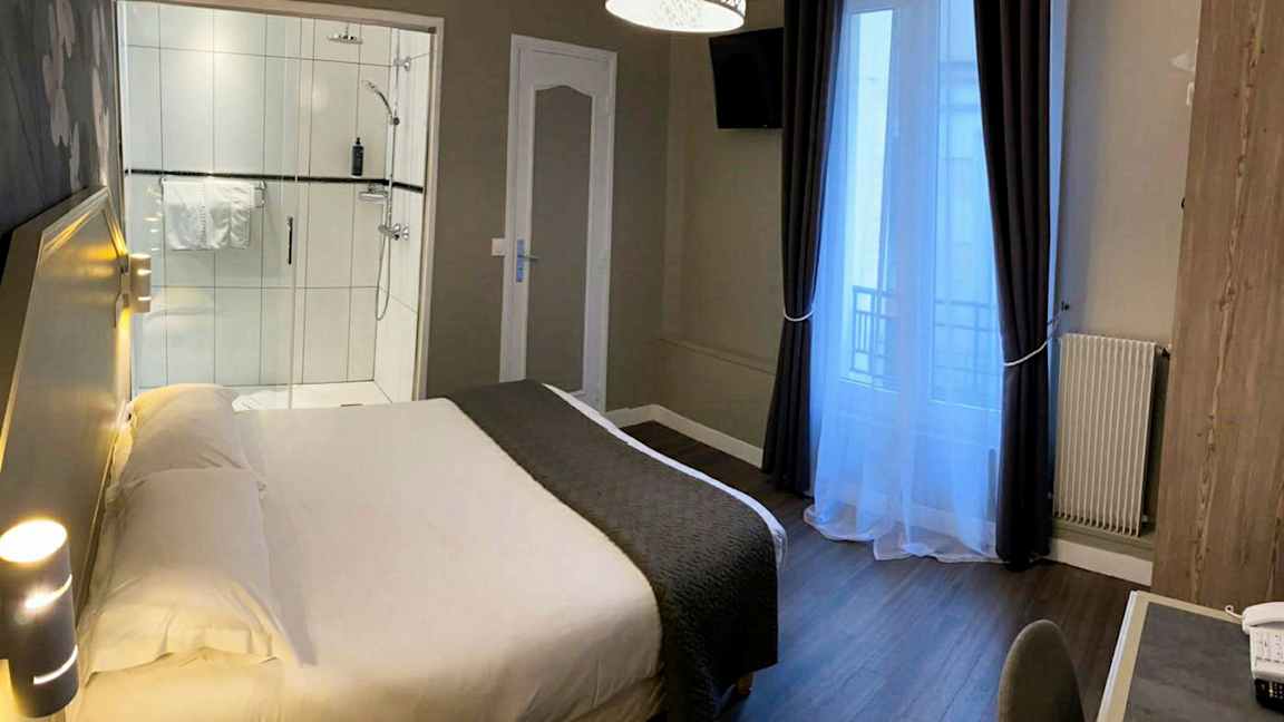 Hotellihuone, jossa sänky, työpöytä ja suihku. (Tekoälyn luoma teksti)