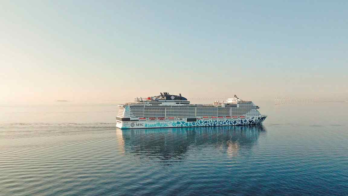 Risteilyalus avomerellä, taustalla tuulivoimaloita. (Tekoälyn luoma teksti)