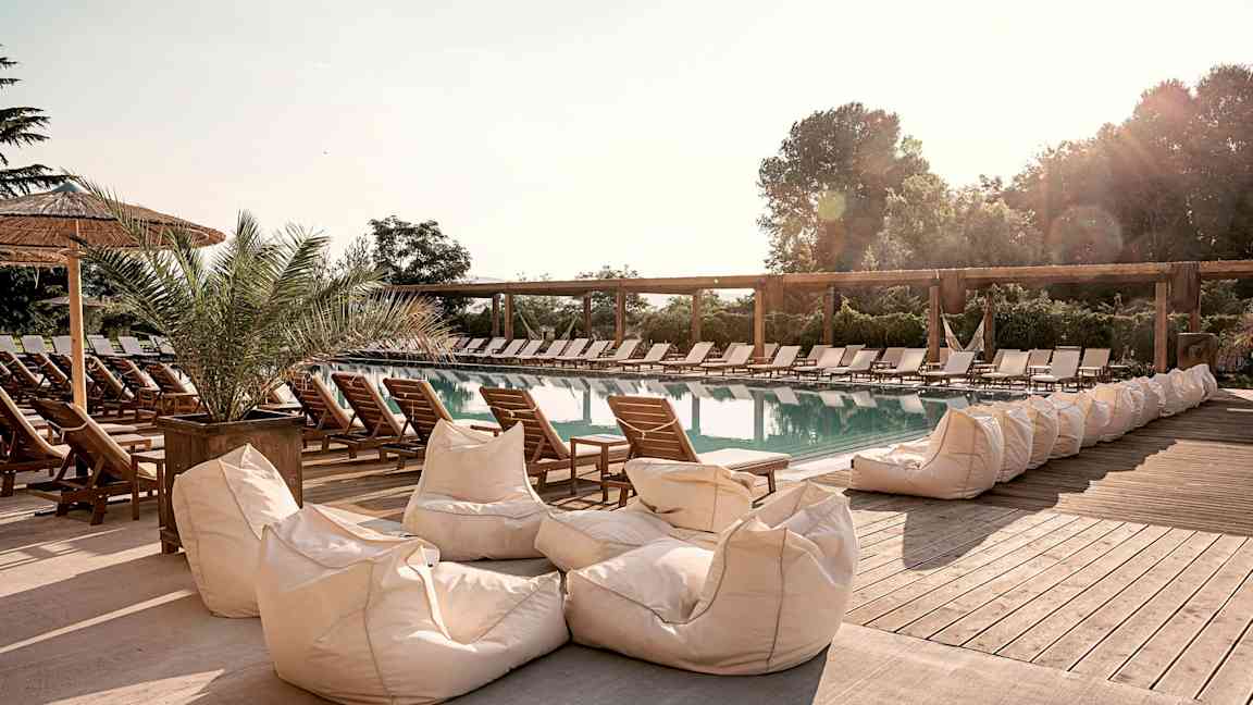 Ulkouima-allas aurinkotuolien ja istuintyynyjen ympäröimänä. (Tekoälyn luoma teksti)