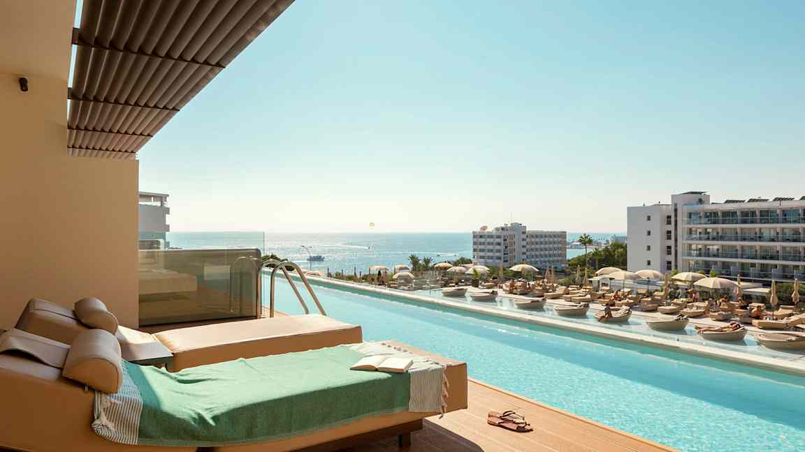 Aurinkotuolit ja uima-allas merinäköalalla lomakohteessa. (Tekoälyn luoma teksti)