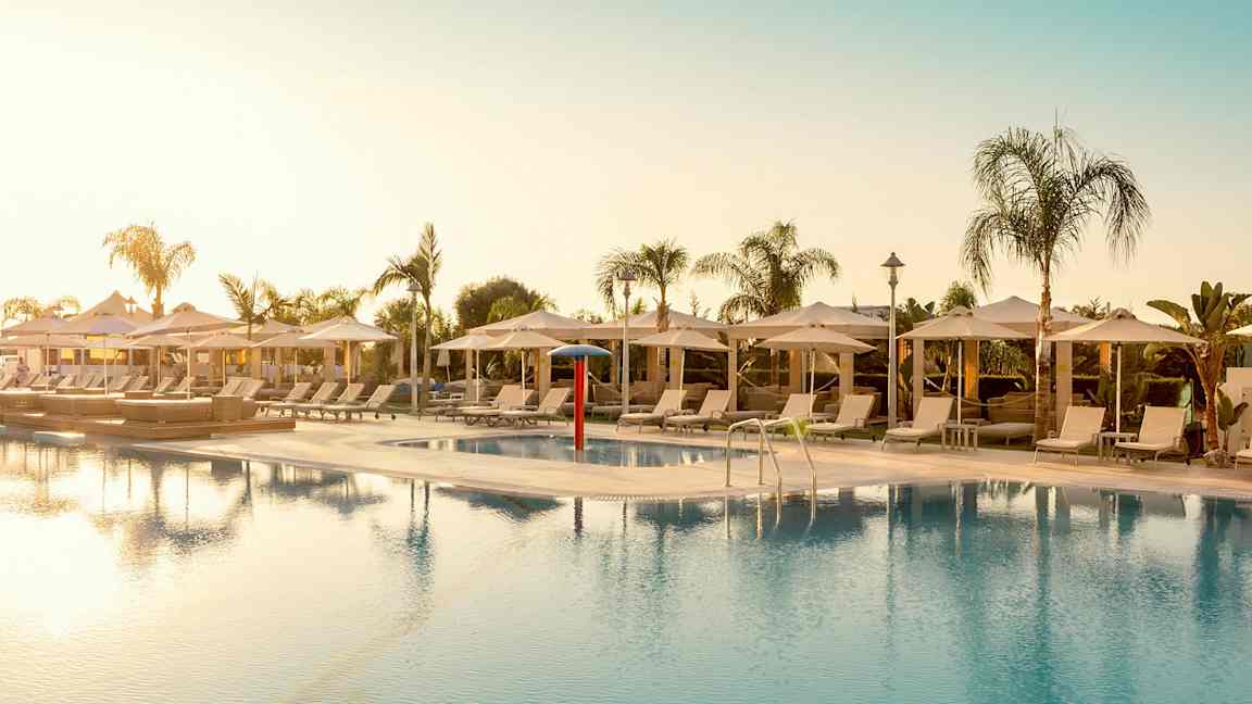 Ulkouima-allas aurinkotuolien ja päivänvarjojen ympäröimänä. (Tekoälyn luoma teksti)