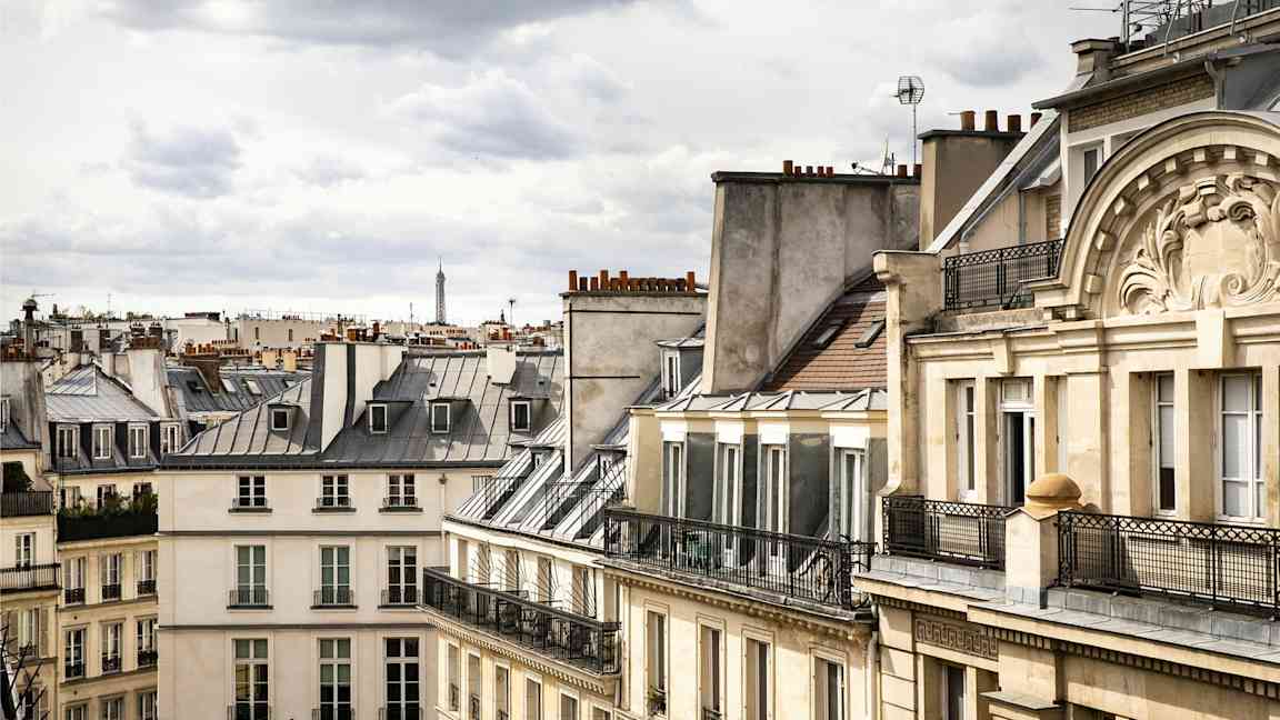 Kuva pariisilaisista rakennuksista, joiden katot ovat tyypillisiä, ja taustalla näkyy Eiffel-torni. (Tekoälyn luoma teksti)