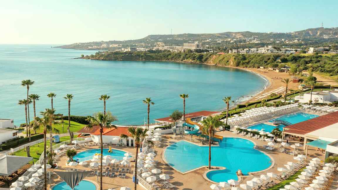 Näkymä hotellialueelta, jossa on uima-altaita, aurinkotuoleja ja merinäköala. (Tekoälyn luoma teksti)