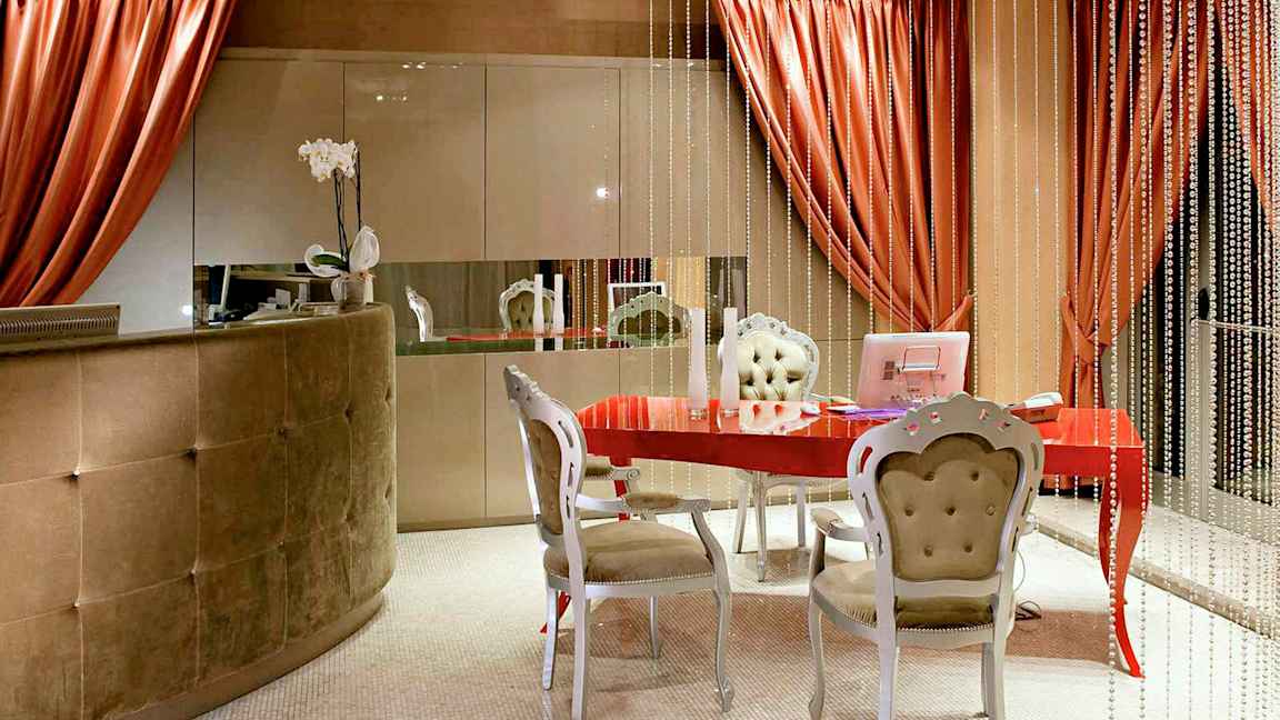 Vastaanottotila, jossa on punainen pöytä, tyylikkäät huonekalut ja koristeellisia elementtejä. (Tekoälyn luoma teksti)