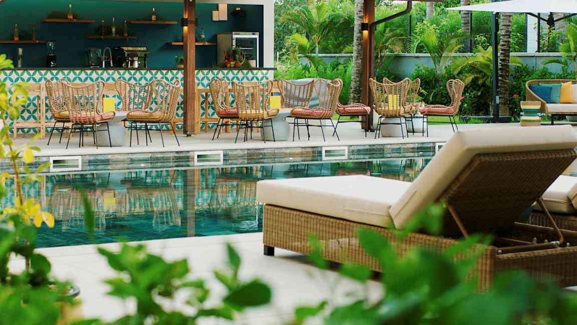 Ulkouima-allas, jossa on aurinkotuoleja ja istuinryhmiä baarin vierellä. (Tekoälyn luoma teksti)