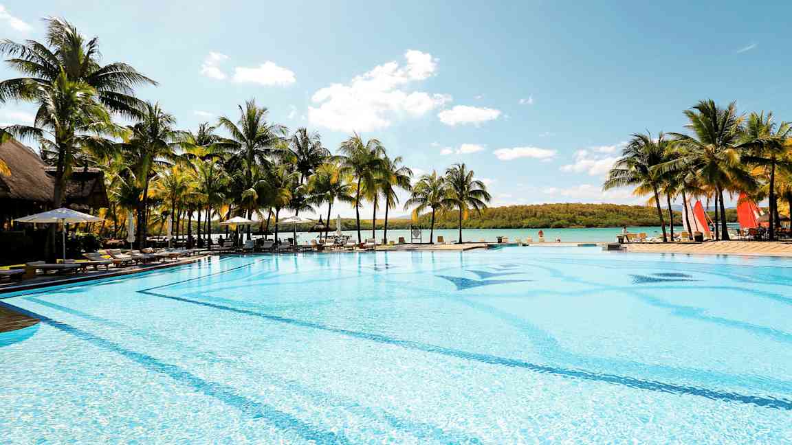 Suuri uima-allas meren rannalla, jota ympäröivät palmut. (Tekoälyn luoma teksti)