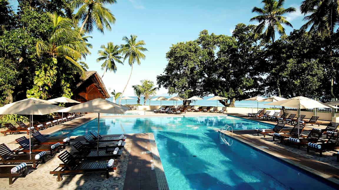 Uima-allas ja aurinkotuolit trooppisella lomakohteella. (Tekoälyn luoma teksti)