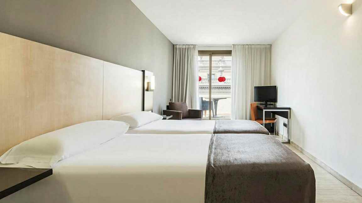 Hotellihuone, jossa kaksi erillistä vuodetta, työpöytä ja parveke. (Tekoälyn luoma teksti)