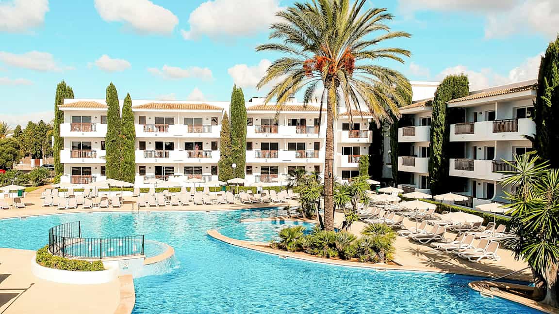 Kuva hotellialueesta, jossa uima-allas ja aurinkotuoleja. (Tekoälyn luoma teksti)