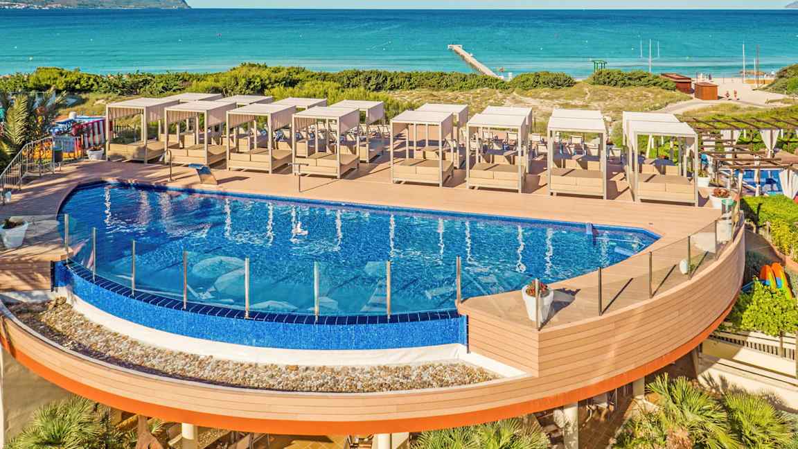 Ulkouima-allas, jossa aurinkotuolit puuterassilla lähellä rantaa. (Tekoälyn luoma teksti)