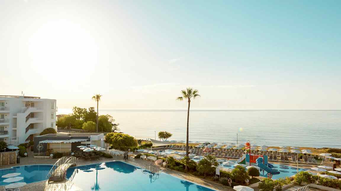 Aurinkoinen lomakohde, jossa on uima-allas ja näkymä merelle. (Tekoälyn luoma teksti)