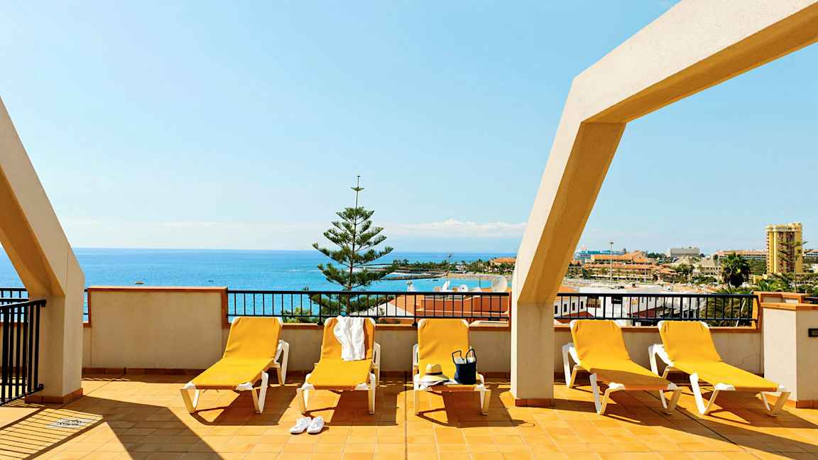 Terassi, jossa aurinkotuoleja ja merinäköala. (Tekoälyn luoma teksti)