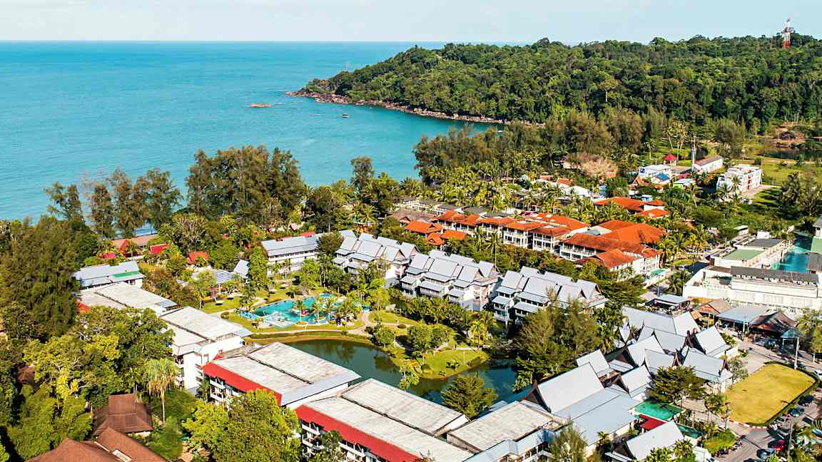 Ilmakuva hotellialueesta, jota ympäröi vehreys ja joka sijaitsee meren äärellä. (Tekoälyn luoma teksti)