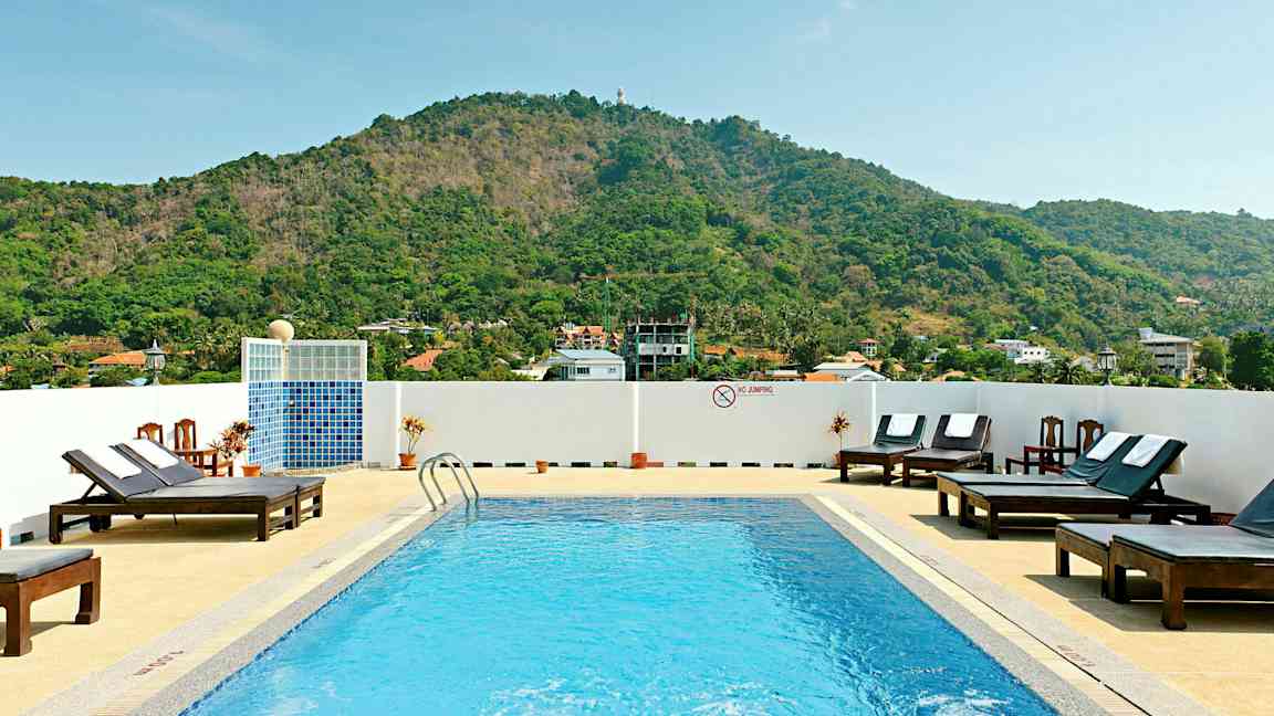 Ulkouima-allas aurinkotuoleilla ja vuoria taustalla. (Tekoälyn luoma teksti)