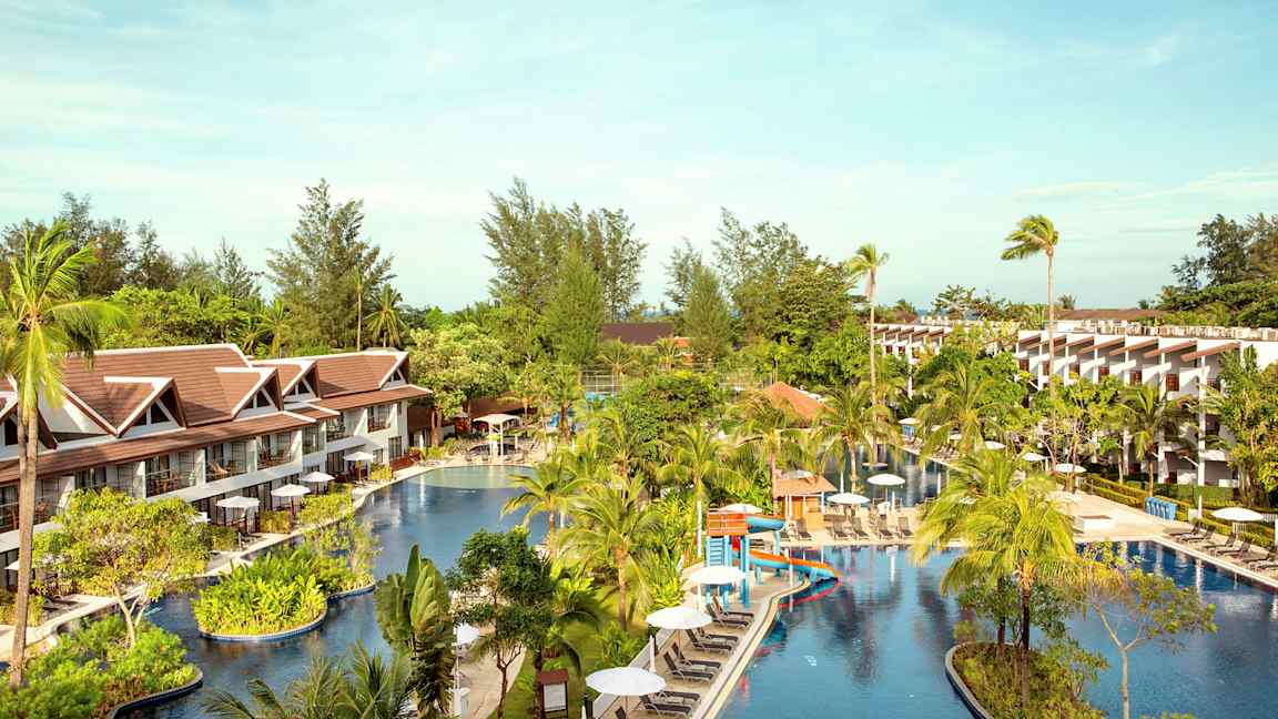 Hotellialue, jolla on suuri uima-allas palmujen ja rakennusten ympäröimänä. (Tekoälyn luoma teksti)