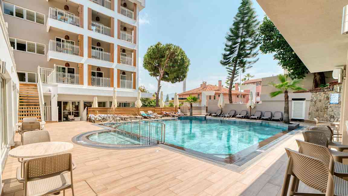 Hotellin ulkouima-allas istuimineen ja aurinkotuoleineen. (Tekoälyn luoma teksti)