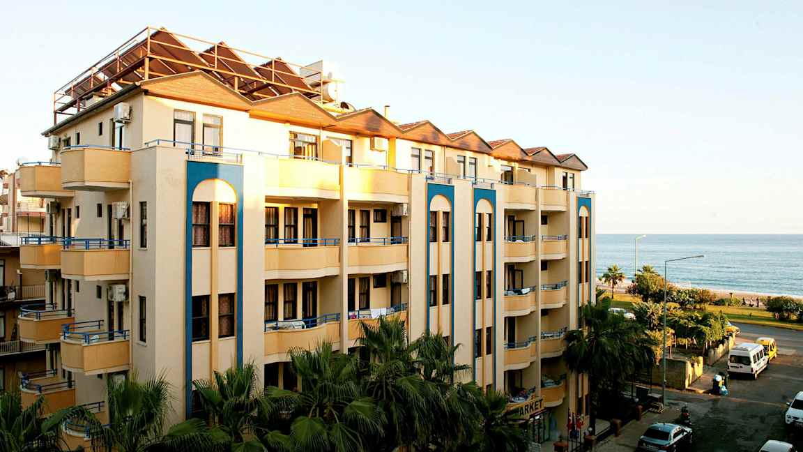 Kuva kerrostalosta, jossa on parvekkeita lähellä merta. (Tekoälyn luoma teksti)