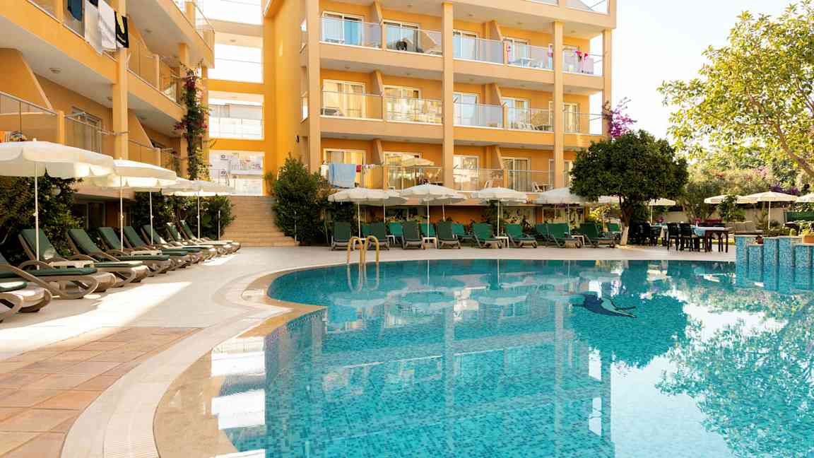 Rakennus parvekkeilla ja uima-allas etualalla. (Tekoälyn luoma teksti)