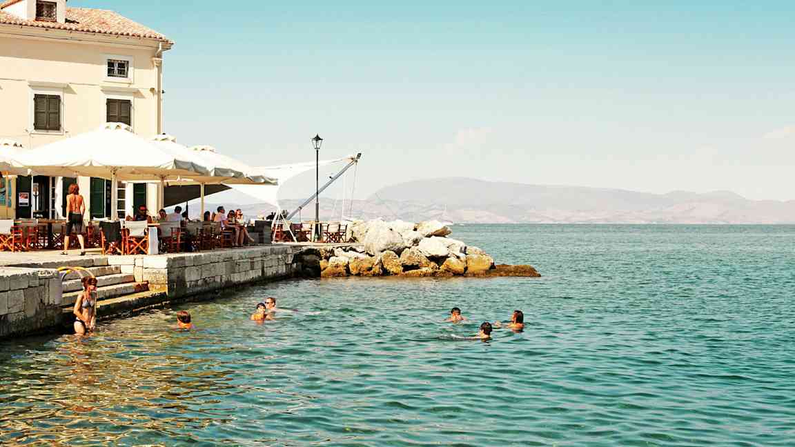 Ihmiset uivat meressä lähellä rantakahvilaa. (Tekoälyn luoma teksti)