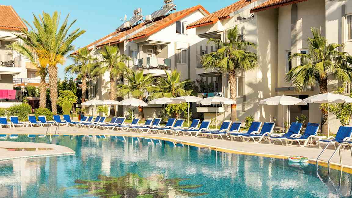 Ulkoallas hotellin vieressä, jossa aurinkotuoleja ja aurinkovarjoja. (Tekoälyn luoma teksti)