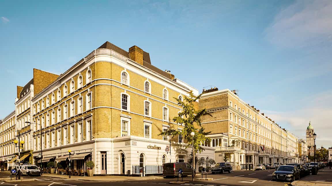 Katu, jossa on rivi klassisia rakennuksia ja pysäköityjä autoja. (Tekoälyn luoma teksti)