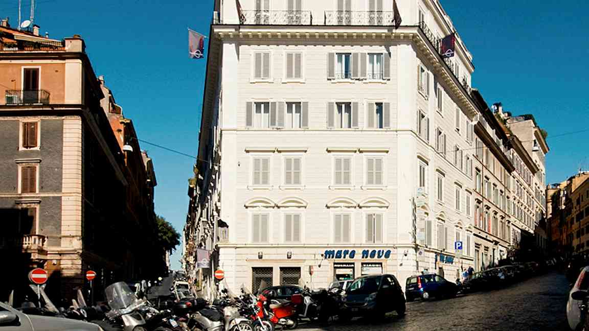 Katu, jossa autoja ja moottoripyöriä rakennusten edessä kaupunkialueella. (Tekoälyn luoma teksti)