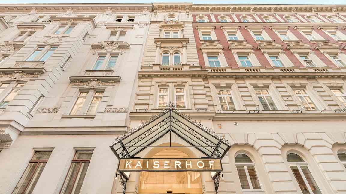Rakennuksen julkisivu, jossa teksti 'Kaiserhof' sisäänkäynnin yläpuolella. (Tekoälyn luoma teksti)