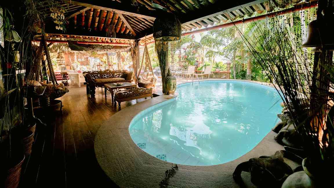 Kodikas tila, jossa sisäuima-allas, puukalusteita ja kasveja ympärillä. (Tekoälyn luoma teksti)