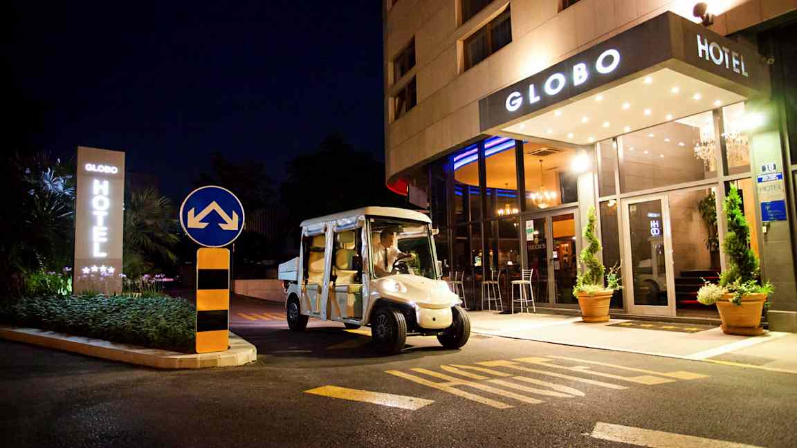 Hotelli nähtynä yöllä nimeltä Globo, sähkökäyttöinen auto on pysäköity sisäänkäynnin eteen. (Tekoälyn luoma teksti)