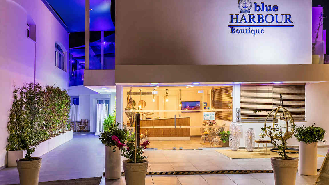 Hotellin sisäänkäynti yöllä, näkyvissä ikkunat ja sisustus. (Tekoälyn luoma teksti)