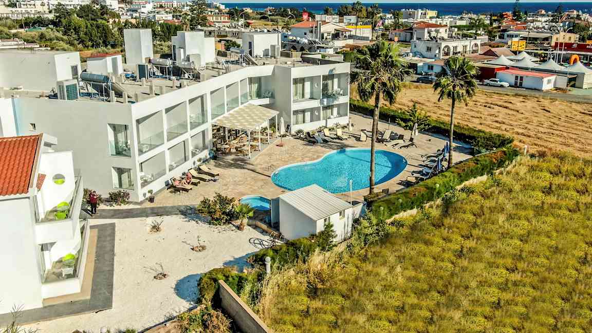 Ilmakuva hotellialueesta, jossa uima-allas ja ympäröivät rakennukset. (Tekoälyn luoma teksti)