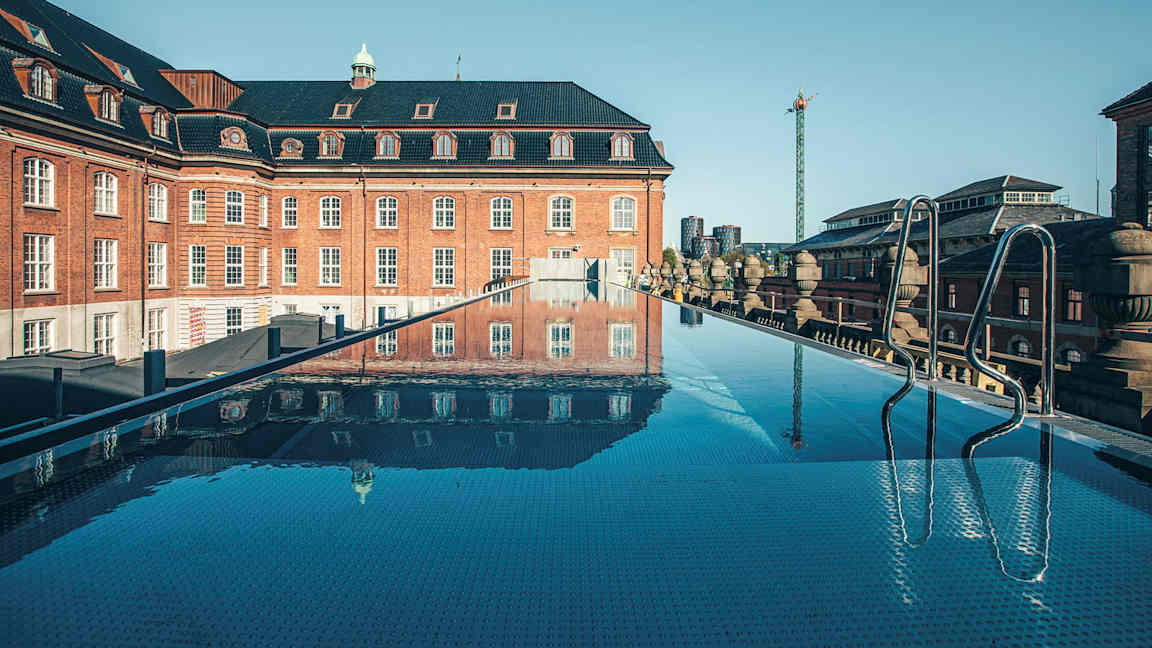 Kattoallas, jolta on näkymä vanhaan tiilirakennukseen. (Tekoälyn luoma teksti)
