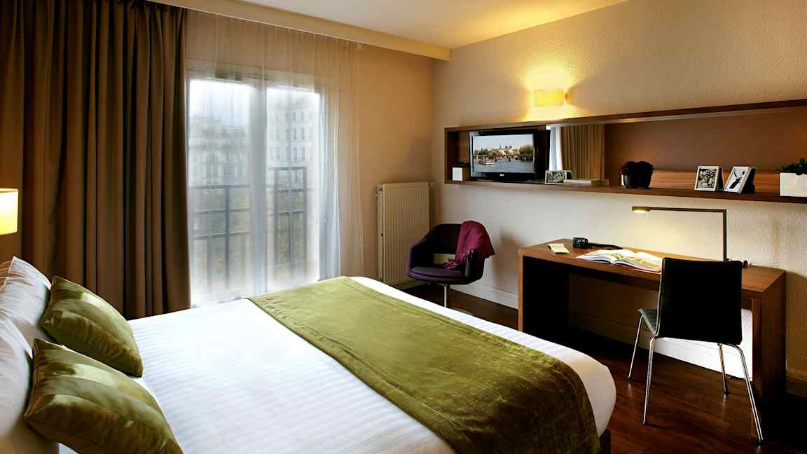 Hotellihuone, jossa parivuode ja työpöytä. (Tekoälyn luoma teksti)