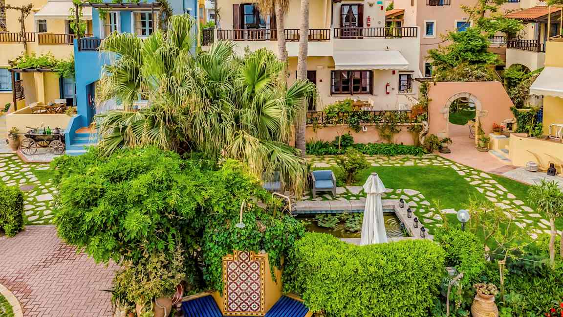 Viehättäviä taloja värikkäillä julkisivuilla, joita ympäröi vehreys ja kukat. (Tekoälyn luoma teksti)