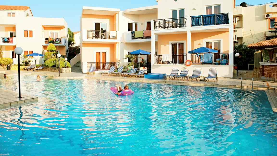 Huoneistoja ulkouima-altaan äärellä, aurinkotuoleilla ja varjoilla. (Tekoälyn luoma teksti)