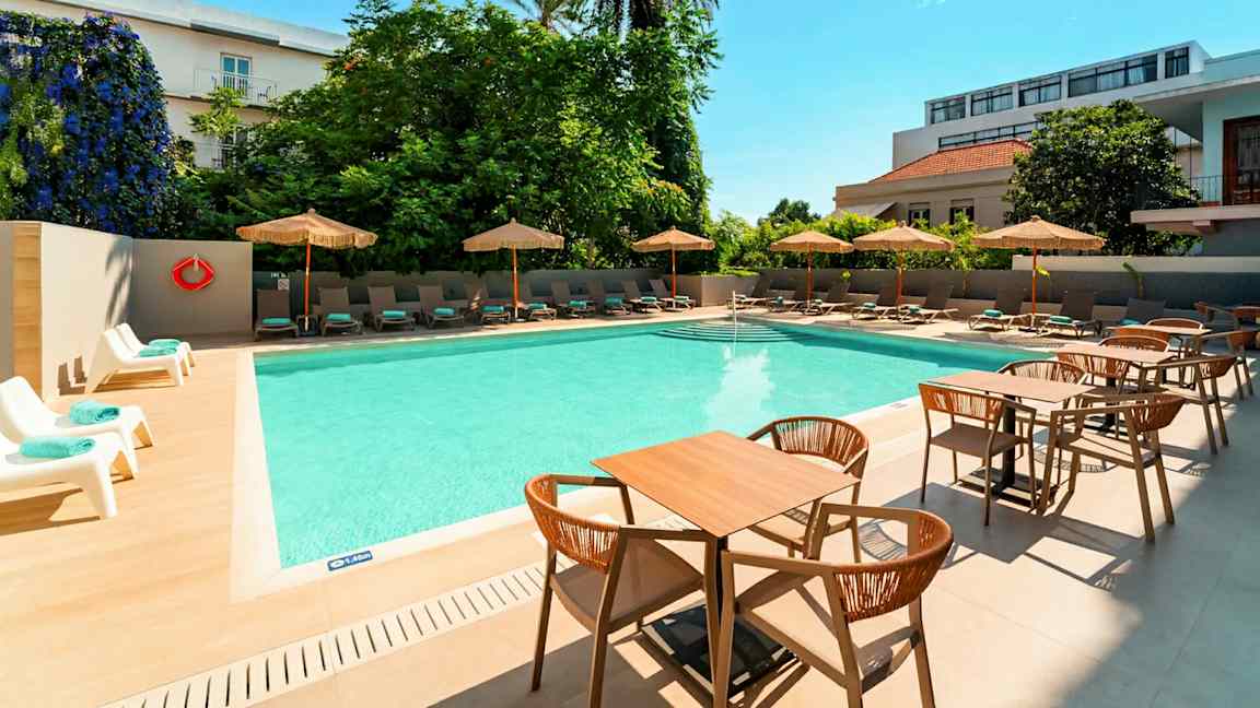 Ulkouima-allas, jonka ympärillä on aurinkotuoleja ja päivänvarjoja sekä etualalla pöytiä ja tuoleja. (Tekoälyn luoma teksti)