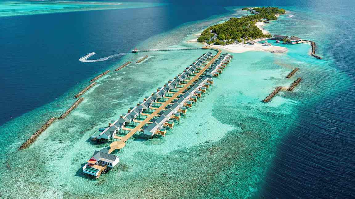 Ilmasta otettu kuva trooppisesta saaresta, jossa on vesihuviloita ja ympärillä turkoosi meri. (Tekoälyn luoma teksti)