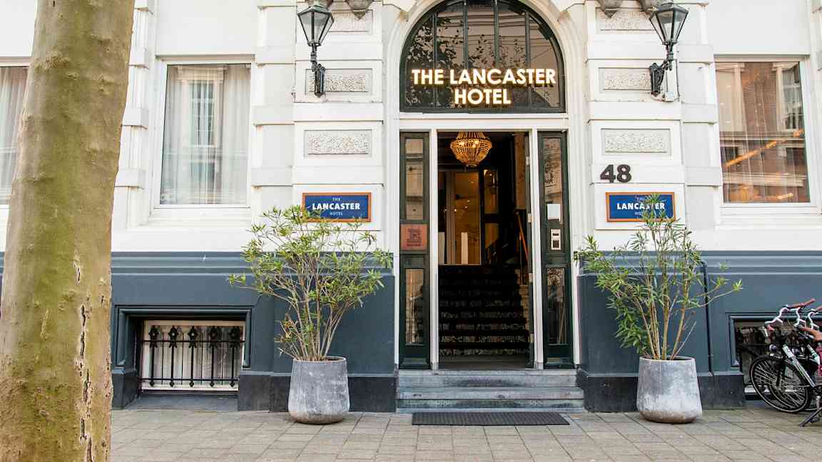 Hotellin sisäänkäynti, jonka yläpuolella on kyltti 'The Lancaster Hotel'. (Tekoälyn luoma teksti)
