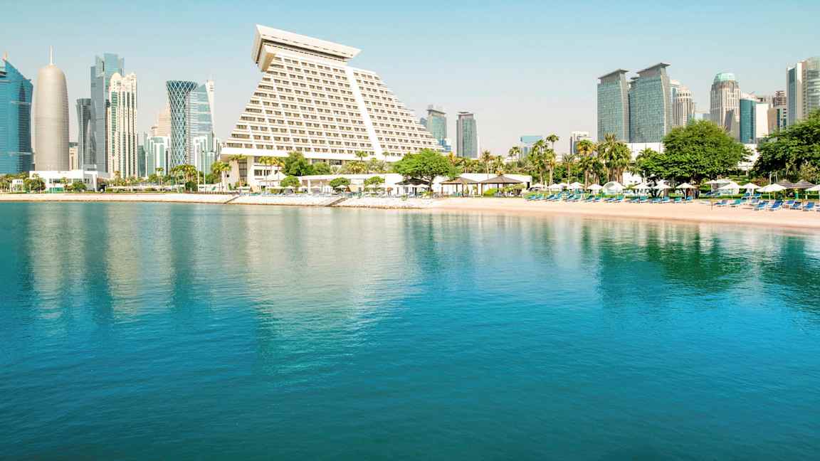 Kuva kaupungista, jossa on modernia arkkitehtuuria rauhallisen rannan ja veden äärellä. (Tekoälyn luoma teksti)