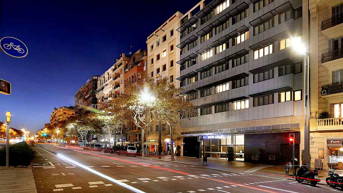 Katu kaupunkimaisemassa yöllä, korkeat rakennukset ja autoja tien varrella. (Tekoälyn luoma teksti)