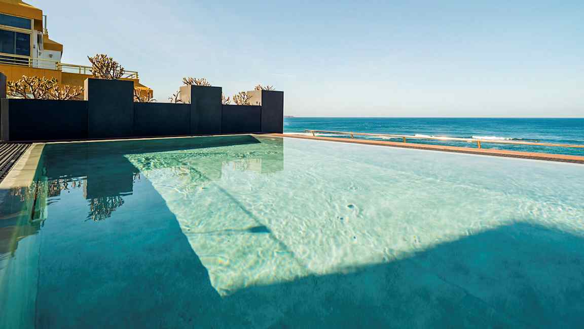 Infinity-allas, josta on näkymä merelle kirkkaan taivaan alla. (Tekoälyn luoma teksti)