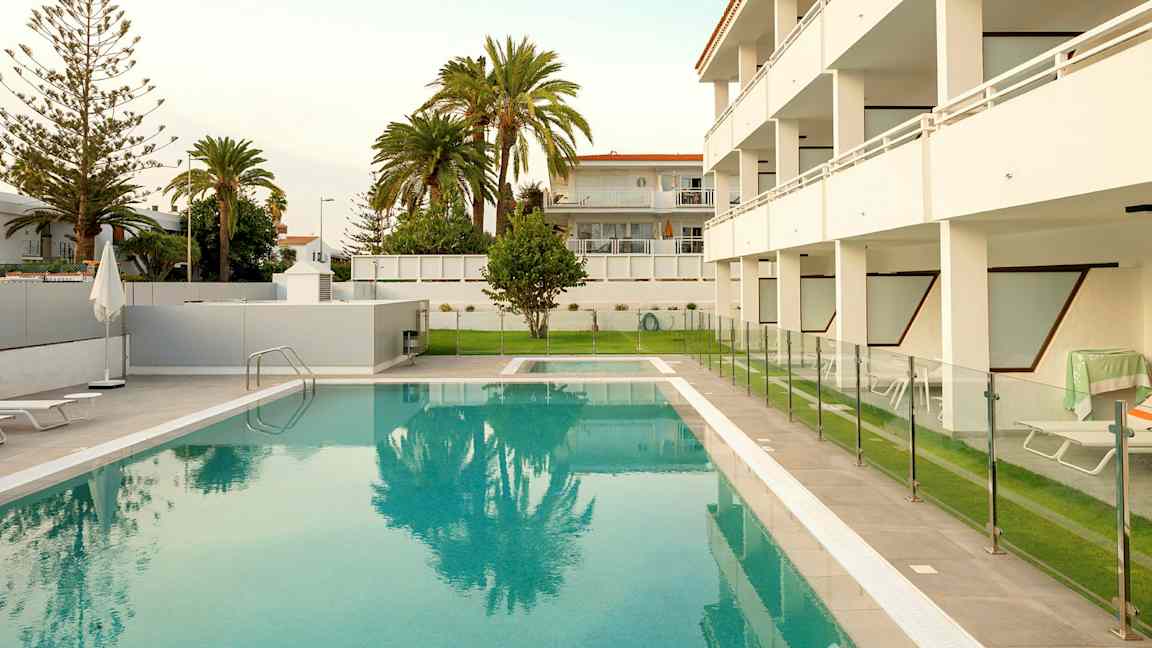 Ulkouima-allas, jonka ympärillä on aita ja taustalla rakennuksia. (Tekoälyn luoma teksti)