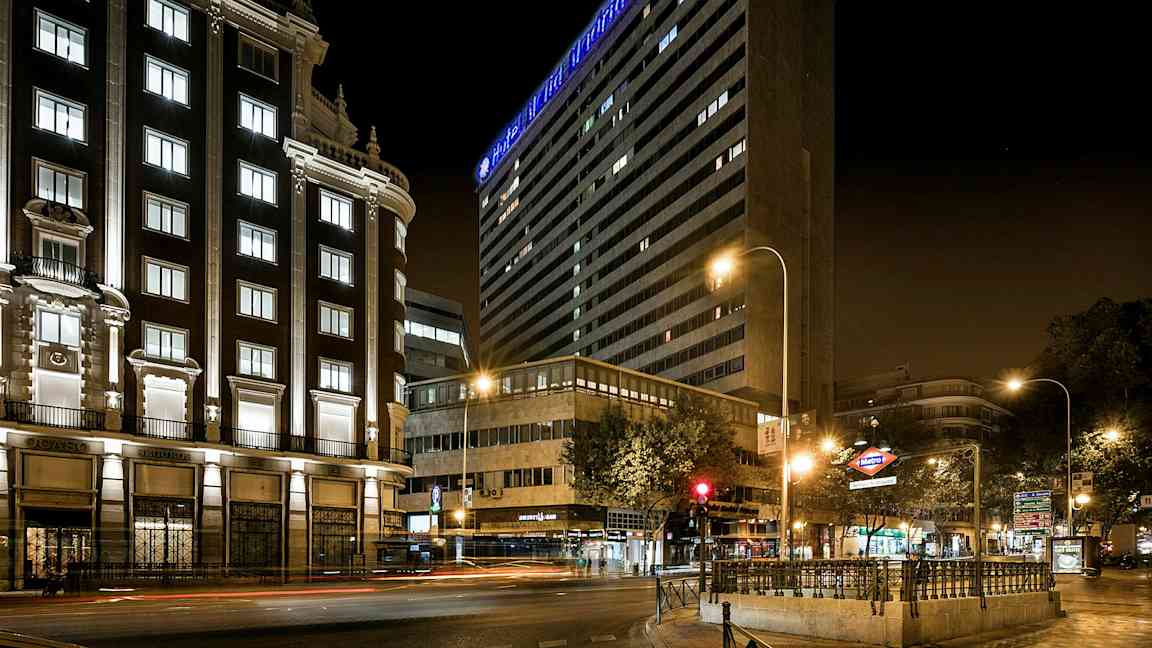 Kaupunkikatu yöllä valaistujen rakennusten ja valokylttien kanssa. (Tekoälyn luoma teksti)