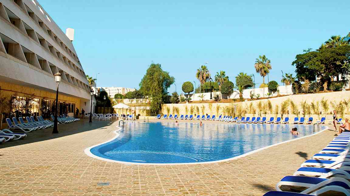 Hotellin uima-allas, jonka ympärillä on aurinkotuoleja. (Tekoälyn luoma teksti)