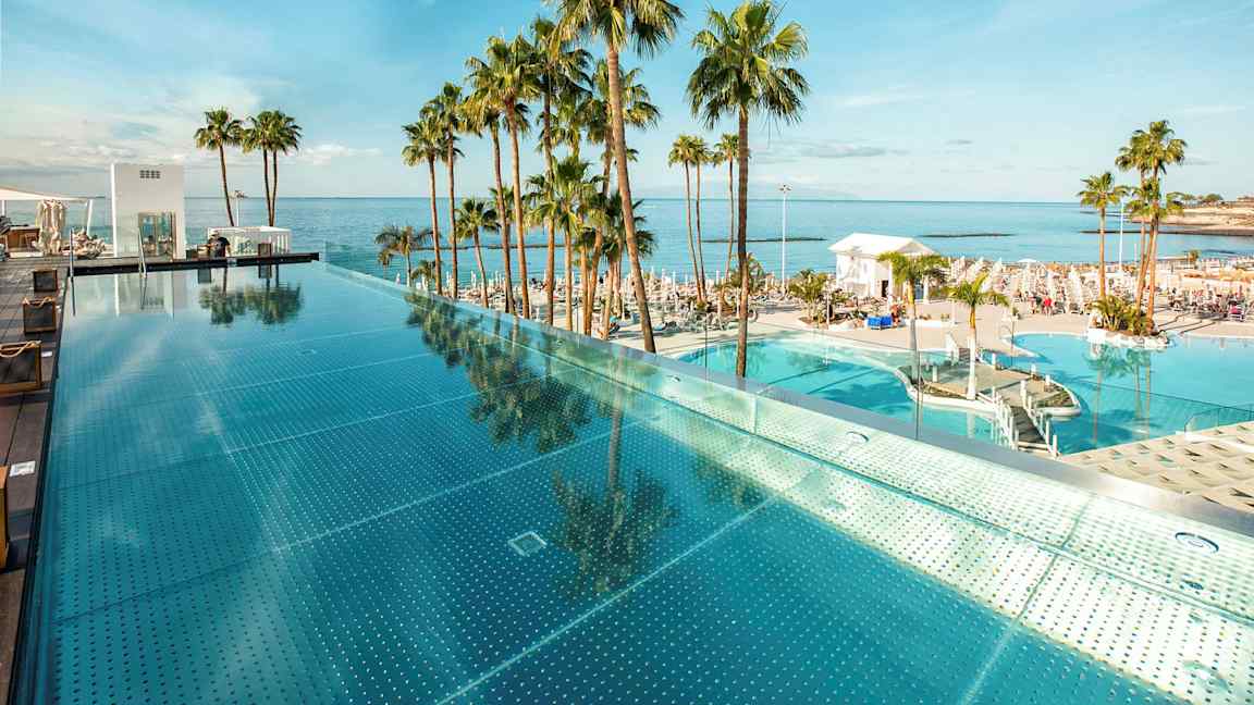 Infinity-allas meren äärellä, ympärillä palmuja. (Tekoälyn luoma teksti)