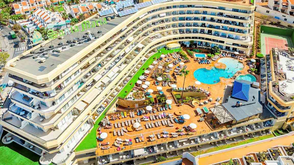 Kuva hotellista, jossa on uima-allasalue ja sitä ympäröiviä lomamajoja. (Tekoälyn luoma teksti)