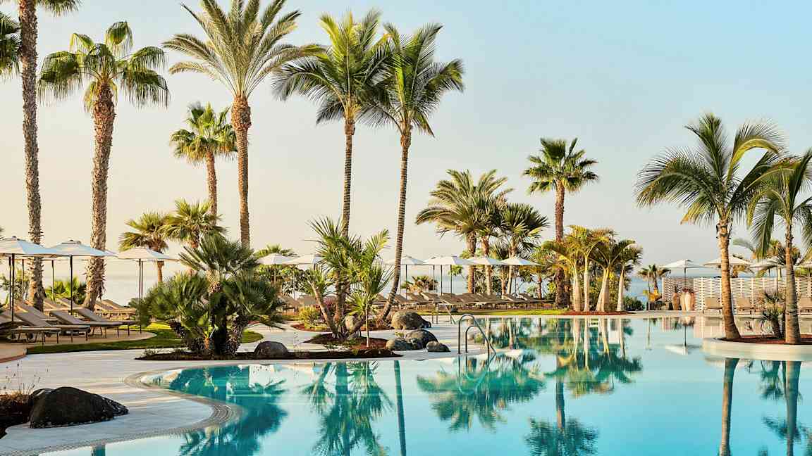 Uima-allasalue, jossa kirkasta sinistä vettä ja palmupuita. (Tekoälyn luoma teksti)