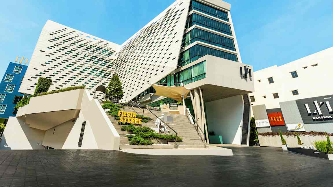 Moderni rakennus, jossa on ainutlaatuinen arkkitehtuuri, suuret lasiosat ja kalteva julkisivu. (Tekoälyn luoma teksti)