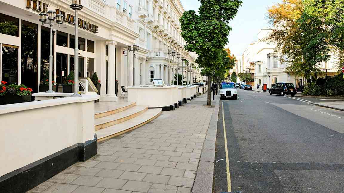 Hotellin julkisivu kadulla, jonka varrella on puita. (Tekoälyn luoma teksti)